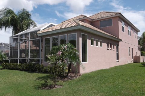 House with new stucco home addition with multiple windows and tile roof