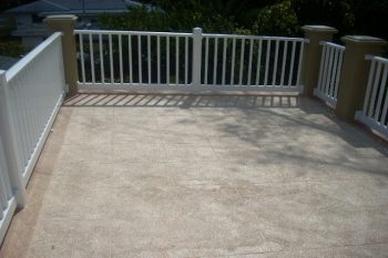 White vinyl railing porch with stucco posts on walkable rooftop