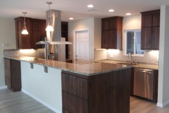 Peninsula kitchen with rebuilt cabinets, lighting and granite countertops