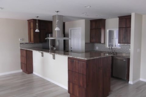 Peninsula kitchen with repurposed cabinets, granite countertops and tile flooring