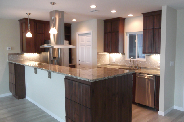 Peninsula kitchen with repurposed cabinets, granite countertops, tile flooring and lights