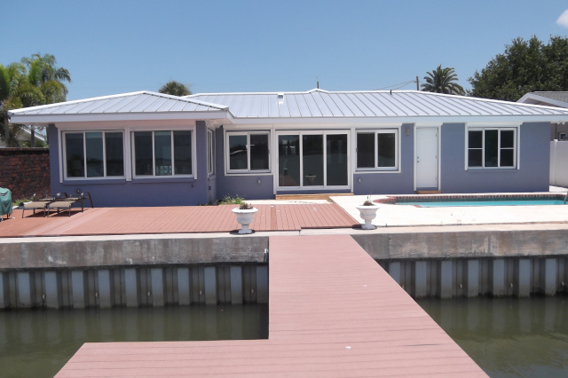 Remodeled house on the water with new windows, sliding glass doors and metal roof