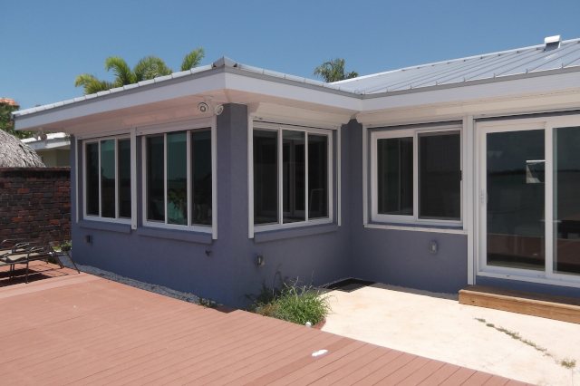 Horizontal slider impact windows on blue stucco walls