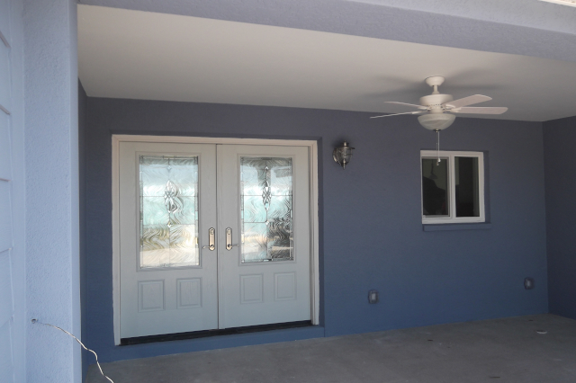 Covered front patio with concrete floor, impact rated window and double entry door
