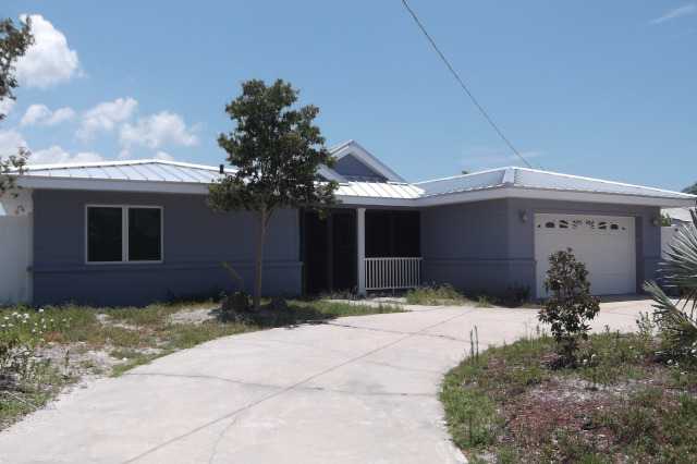 Street view of remodeled house with fiber cement siding and metal roof