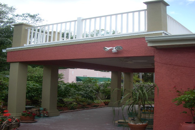 Side view of sun deck balcony with stucco columns and vinyl railings
