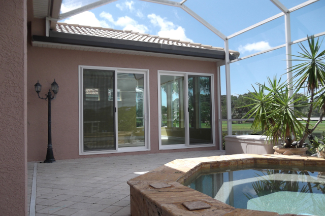 Sunroom Addition Sliding Glass Doors Hot Tub Impact rated sliding glass doors opening to screen room patio with granite pavers