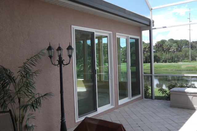 Exterior Sunroom Sliding Doors Patio Impact rated sliding glass doors on home addition with granite patio overlooking pond